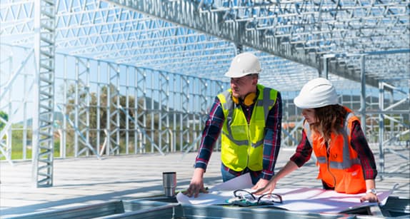 Estructura metálica de galpón con trabajadores en obra